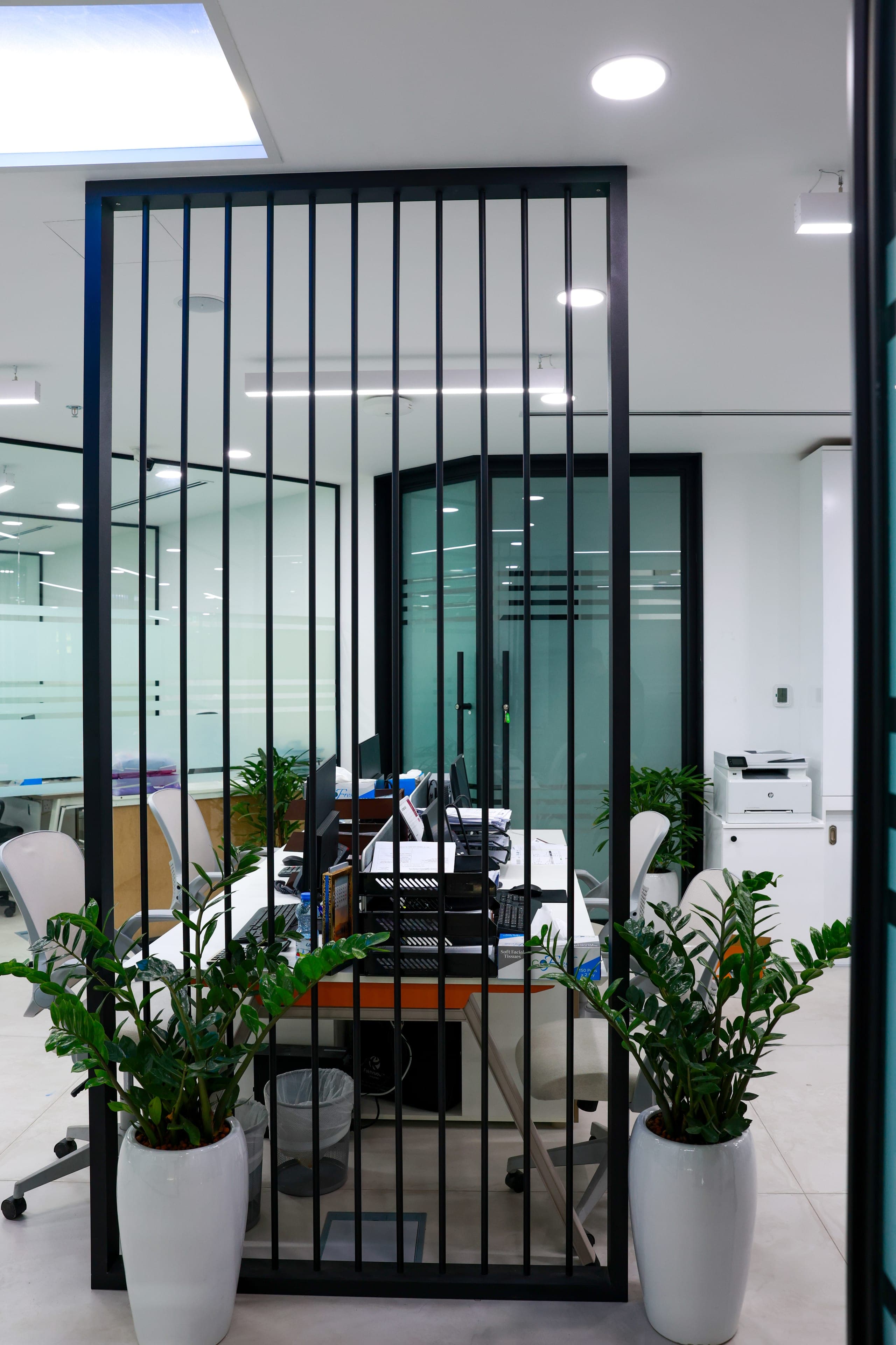 A steel grid screen dividing office from circulation