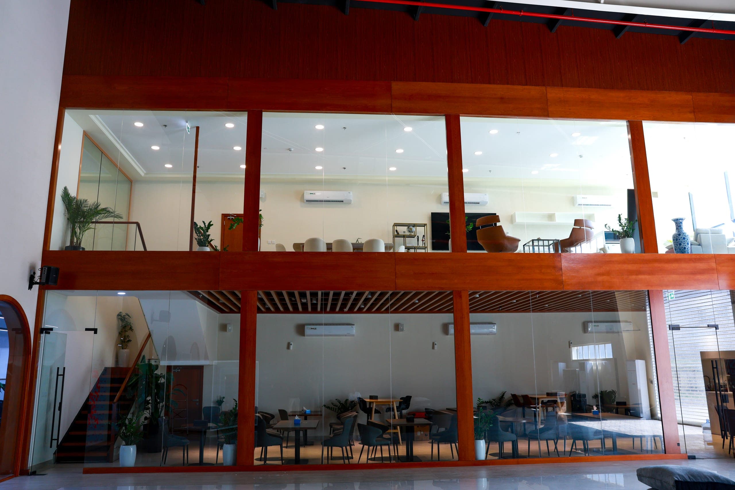 A mezzanine edge in painted steel above the dining floor