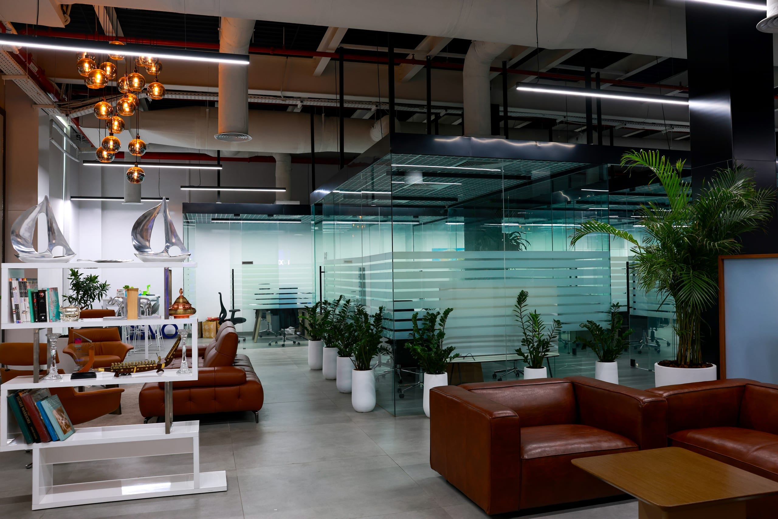 A completed office lounge: leather seating and planting against glazed partitions